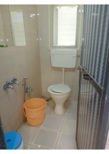 a bathroom with a toilet and a window and a tub at Aangan Villa in Alibaug