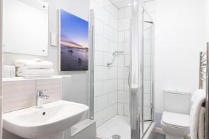 a bathroom with a shower, sink, and toilet at The Marine Hotel in Llandudno