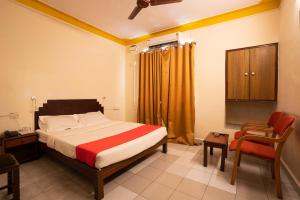 1 dormitorio con cama, escritorio y silla en The Sincro Hotel en Madgaon