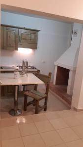 kuchnia ze stołem, krzesłem i kuchenką w obiekcie Savina's House 2 w mieście Veglie