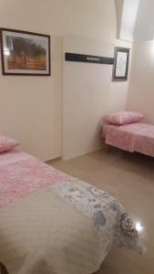 sypialnia z 2 łóżkami i różową pościelą w obiekcie Savina's House 2 w mieście Veglie