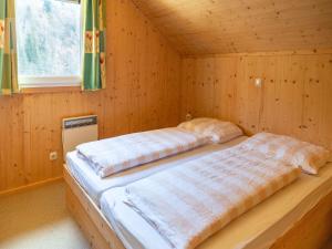 a bed in a wooden room with a window at Holiday home in Styria with balcony in Stadl an der Mur