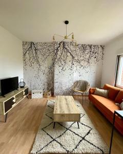 ein Wohnzimmer mit einem Sofa und einem Tisch in der Unterkunft LA VILLA DEKO - Appart2 - Université et Hôpital in Beuvry