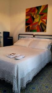 1 cama blanca grande con una pintura en la pared en The lighthouse room en Stromboli