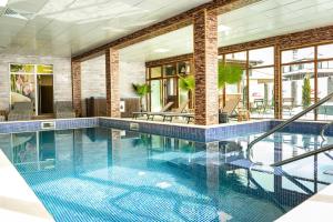 a swimming pool with blue tiles on the floor and windows at Zarevata Guest House in Velingrad