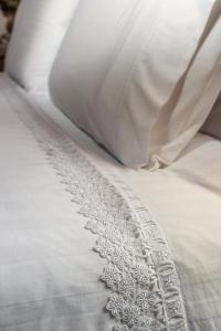 a close up of a white bed with an embroidery at ARCHONTARIKI Historic Boutique Hotel in Ioannina