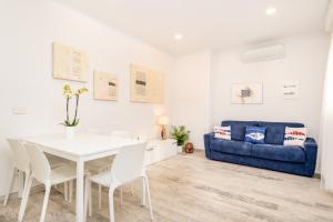 comedor con mesa y sofá azul en Appartamento Rina, en Levanto