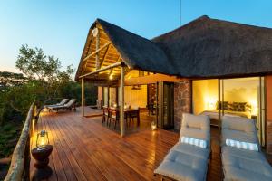 a wooden deck with chairs and a house at Elephants Crossing in Welgevonden Game Reserve