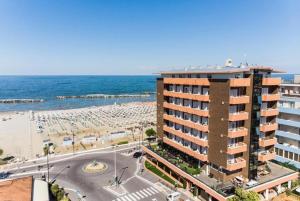 リミニにあるHotel Palazzo Cavejaのホテルとビーチの景色を望めます。