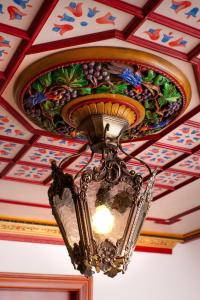 a chandelier hanging from a ceiling with a painted ceiling at ARCHONTARIKI Historic Boutique Hotel in Ioannina