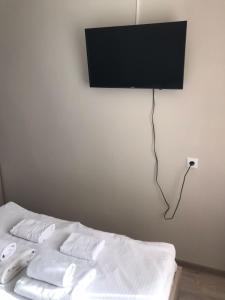 a bedroom with a bed with a television on the wall at Гостиница Kokshe Inn in Kokshetau