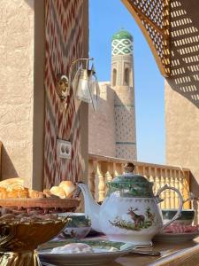 einen Wasserkocher und eine Schüssel Brot auf dem Tisch in der Unterkunft Khiva Amir Tora B&B in Xiva