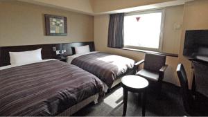 Säng eller sängar i ett rum på Hotel Route-Inn Hikone