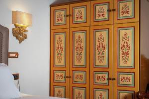 a wooden cabinet with patterns on it next to a bed at ARCHONTARIKI Historic Boutique Hotel in Ioannina