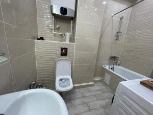 a bathroom with a toilet and a sink and a tub at Lovely house in the city center in Bishkek