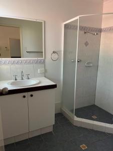
a bathroom with a shower, sink, and toilet at Habitat Resort in Broome
