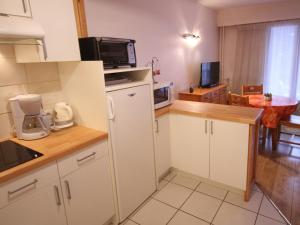 een keuken met witte kasten en een magnetron bij Studio Brides-les-Bains, 1 pièce, 2 personnes - FR-1-512-205 in Brides-les-Bains