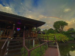 um arco-íris está no céu sobre um edifício em Baan Krupong em Ban Tha Thong Mon