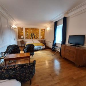 une chambre d'hôtel avec un lit et une télévision dans l'établissement Les Chambres du Château du Rozel, à Le Rozel