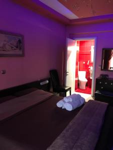 a purple room with a bed with towels on it at Apartament in Aridaia