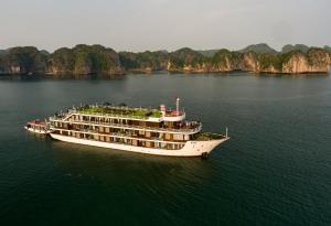 a cruise ship in the water in front of limestone cliffs at La Casta Regal Cruise in Ha Long