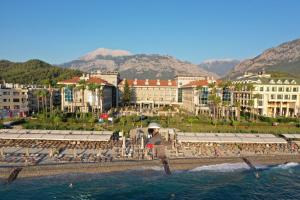 a group of people standing on a beach near the water at Fame Residence Kemer & Spa in Kemer