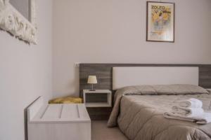 a white bedroom with a bed and a table at Hotel Domus in Maranello
