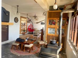 a living room with a wood stove and a table at Redeem Cafe & Homestay in McLeod Ganj