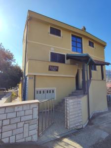 a yellow building with a gate in front of it at Soleil Apartmanok Baska in Baška