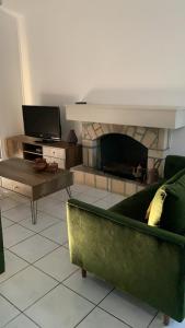 a living room with a green couch and a fireplace at Villa Anna Maria in Coral Bay