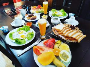 una mesa cubierta con platos de comida y bebida para el desayuno en Queen's Gate, Mirissa, en Mirissa