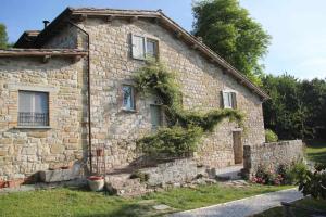 een oud stenen huis met klimop erop bij Agriturismo Montesalce in Gubbio