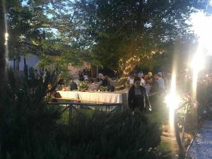 un groupe de personnes debout autour d'une table dans un jardin dans l'établissement Agriturismo Montesalce, à Gubbio