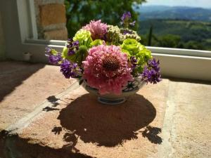 un vase rempli de fleurs assis sur un rebord de fenêtre dans l'établissement Agriturismo Montesalce, à Gubbio