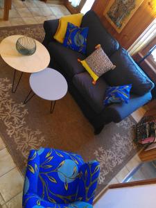 a living room with a blue couch and a table at À Flanc de Montagne in Le Trétien