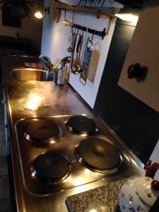 a stove top in a kitchen with a sink at À Flanc de Montagne in Le Trétien