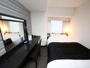 東京にあるアパホテル〈京成上野駅前〉のベッド2台とデスクが備わるホテルルームです。