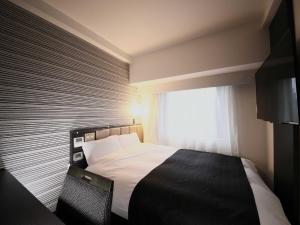Un dormitorio con una cama grande y una ventana en APA Hotel Keisei Ueno Ekimae, en Tokio