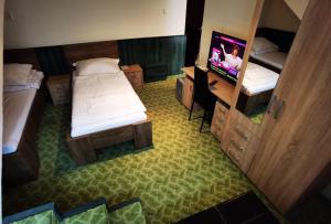 vistas a un dormitorio con 2 camas y TV en KOMPLEX -Rendezvénytermek-Panzió-Apartman-Irodák-, en Mátészalka 30 fotos más