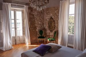 sypialnia z łóżkiem i kamienną ścianą w obiekcie Dimora Aretusa Luxury w Syrakuzach