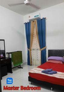 a bedroom with a bed with blue curtains in it at AZ Homestay Bertam Perdana With Free Wifi in Kepala Batas