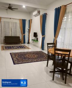 AZ Homestay Bertam Perdana With Free Wifi في كيبالا باتاس: غرفة معيشة مع طاولة وكراسي وأريكة