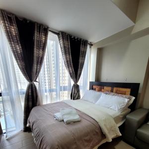 1 dormitorio con 1 cama con 2 toallas en Andy's Place One Eastwood Tower 1, en Manila