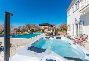 - un bain à remous dans l'arrière-cour d'une maison dans l'établissement Spacious villa Vito with large pool, à Tinj