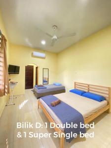 1 dormitorio con 2 camas y almohadas azules en TWIN ROOMSTAY en Kuala Terengganu