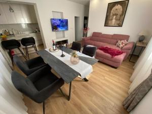 a living room with a table and a pink couch at apartment in the city center in Split