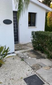 una casa con una puerta negra y una pasarela de piedra en Villa Anna Maria, en Bahía de Coral