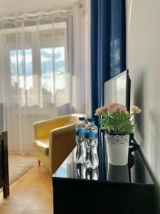 a living room with a table with water bottles and flowers at Domowe Zalesie in Piaseczno