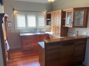 a large kitchen with wooden cabinets and a sink at Beachfront Villa in Napier