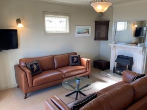 ein Wohnzimmer mit 2 Sofas und einem Kamin in der Unterkunft Beachfront Villa in Napier
